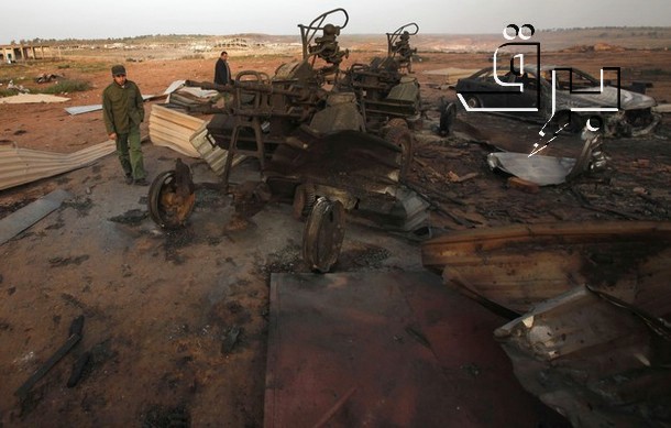 Rebels inspect a destroyed weapons dump near Benghazi